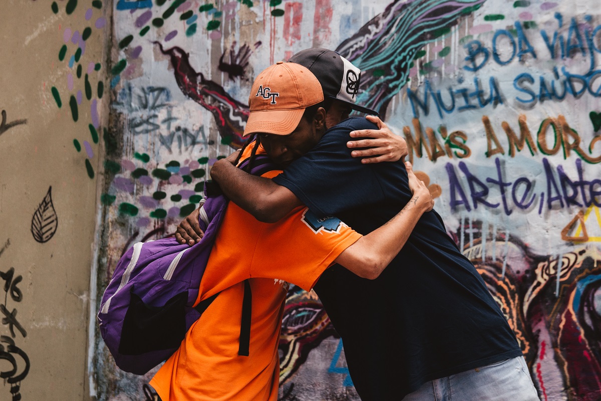 A group leader embraces a teen during Nós Group