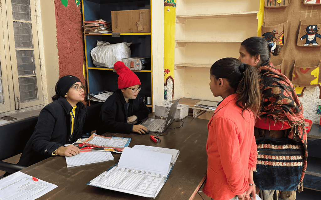 Staff members at the Educational Sponsorship Programme helping students with forms and computer work