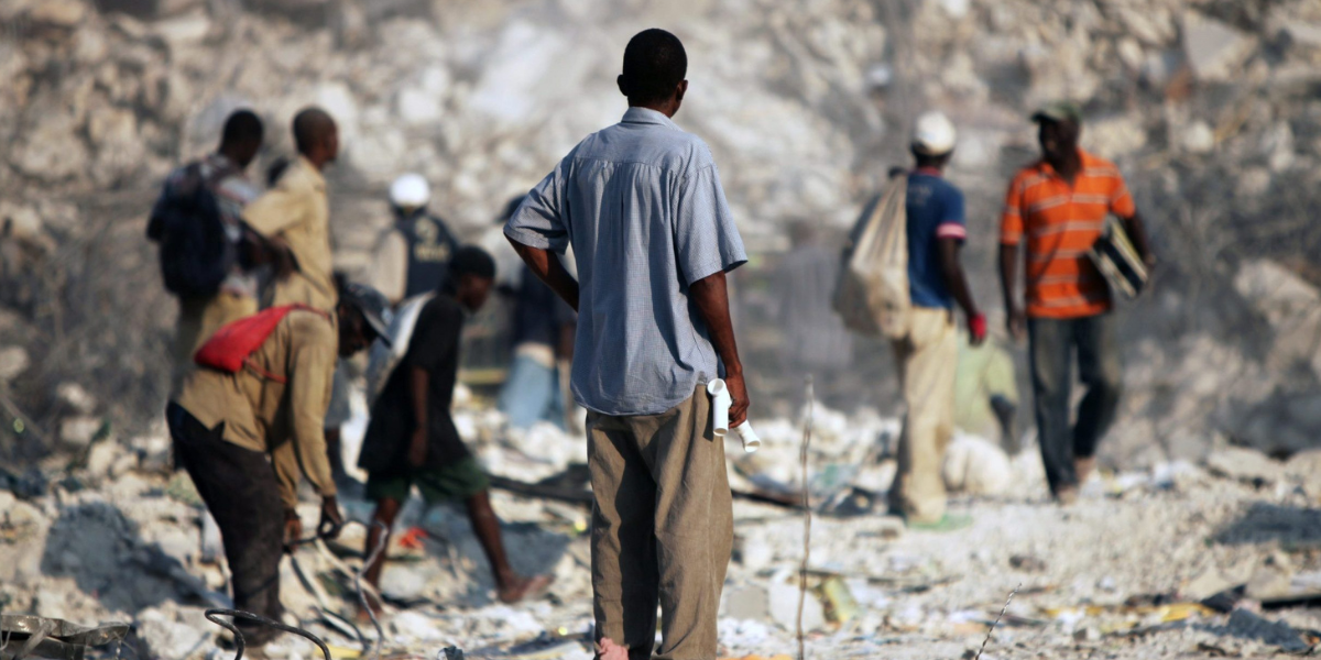 Group of people surveying destruction from hurricane - Hope for Haiti